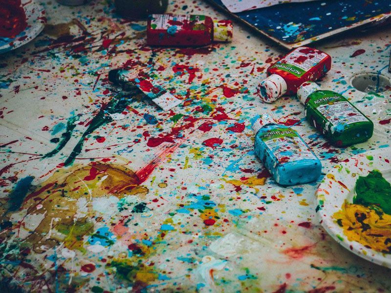 Paint tubes with splattered paint all over an artist's table