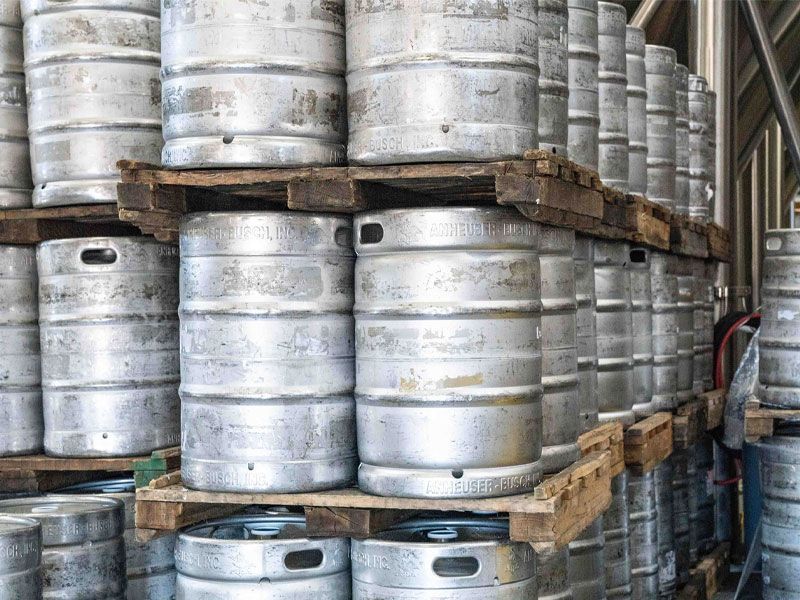 Beer kegs stacked on crates in a warehouse