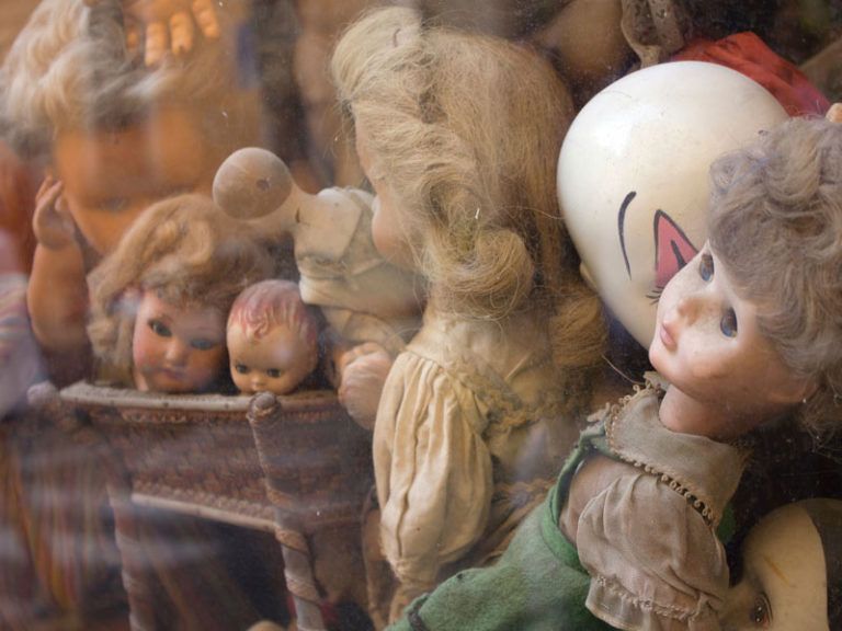 Old porcelain dolls behind glass