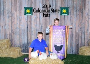 Two boys posing with their prize chickens