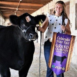 Colorado State Fair steer champ female standing next to her steer
