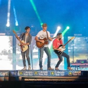 3 boys playing guitar on stage