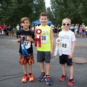 3 young male participants of the Stampede 5K Race & 2-Mile Fun Walk at the Colorado State Fair & Rodeo pose with their ribbons.