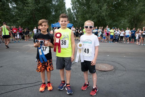 3 boys holding ribbons at the stampede fun walk