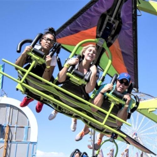 parents and a child riding a green handglide ride at the Colorado State Fair