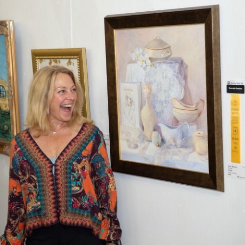 Woman smiling while looking at art at an art exhibit