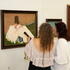 Two women looking at art during an art exhibit
