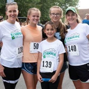 5 teen female participants of the Stampede 5K Race & 2-Mile Fun Walk at the Colorado State Fair & Rodeo pose with their ribbons.