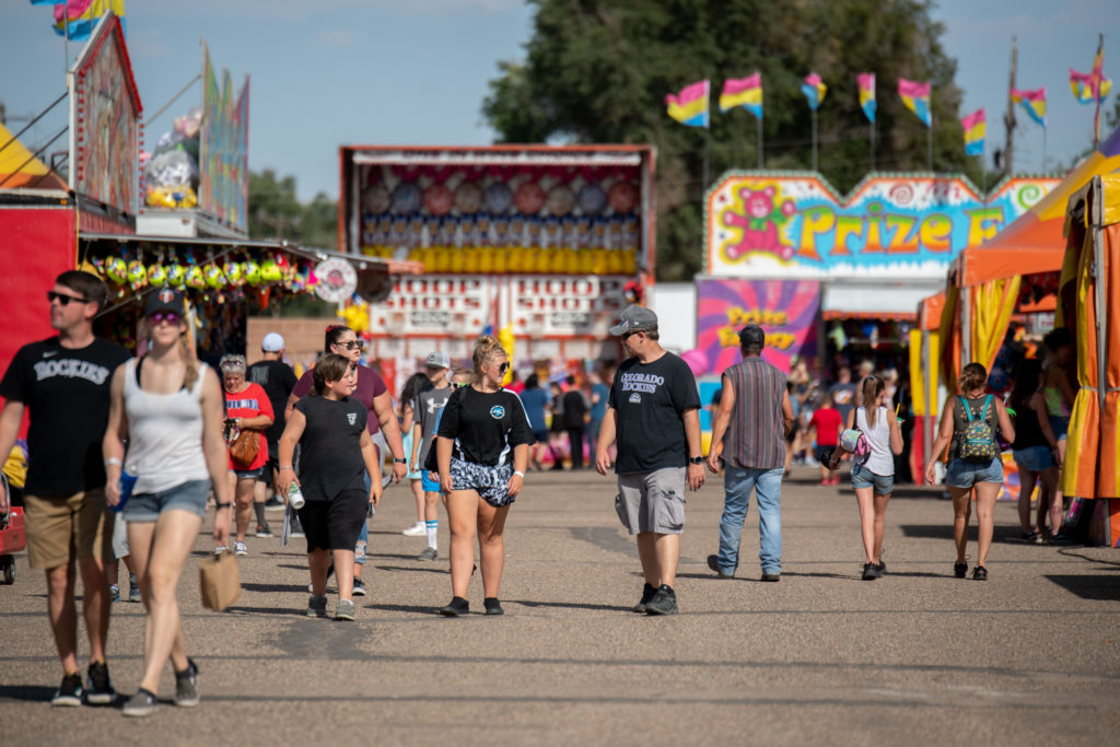 People walking down the midway at the Colorado State Fair on a sunny day