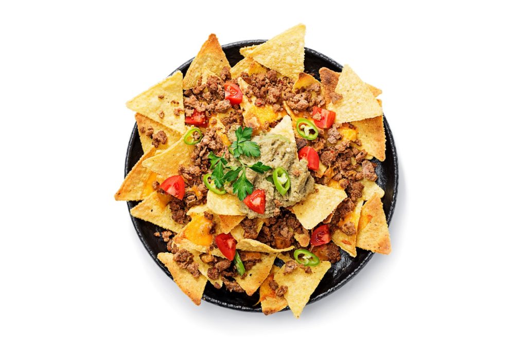 Top view of Rocky Mountain Nachos piled with ground beef, cheese and a sprinkling of tomato and cilantro