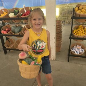 girl holding basket of produce