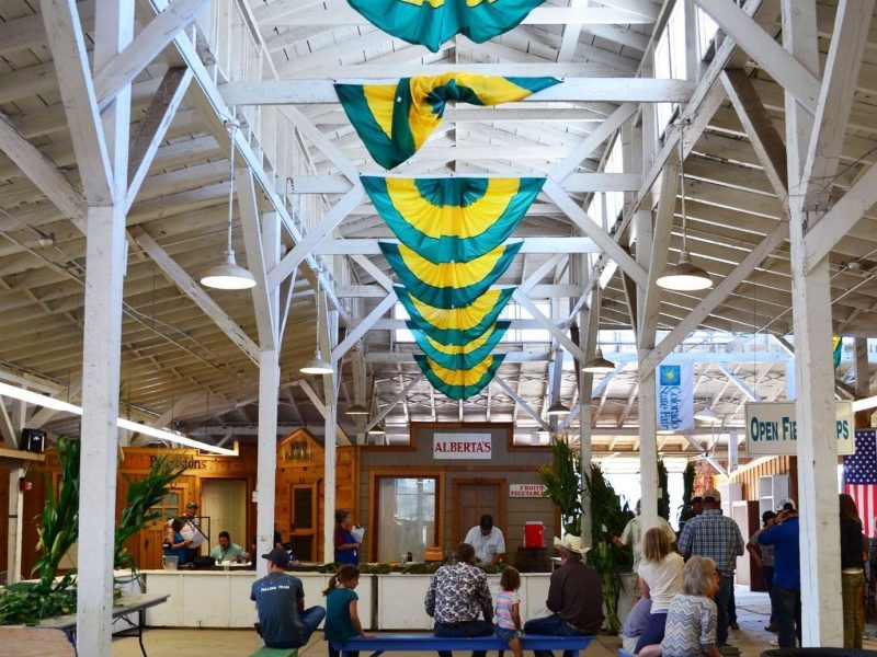 Colorado state fair banners hanging from white rafters